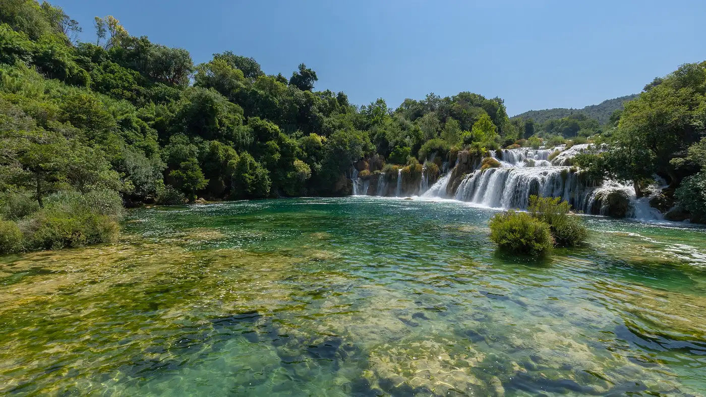 The wide tufa barriers of the Krka waterfalls with boardwalks curving across the cascades